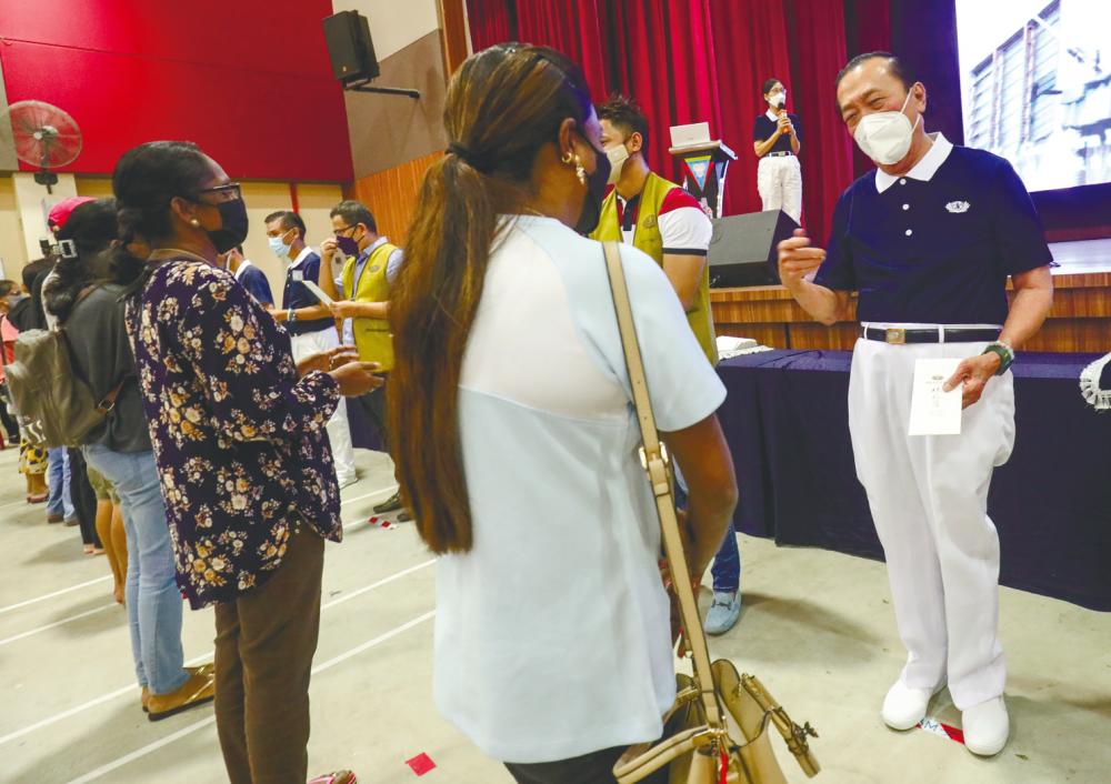 Tan talking to some of the recipients at the Tzu Chi cash relief distribution ceremony. – ASYRAF RASID/THESUN