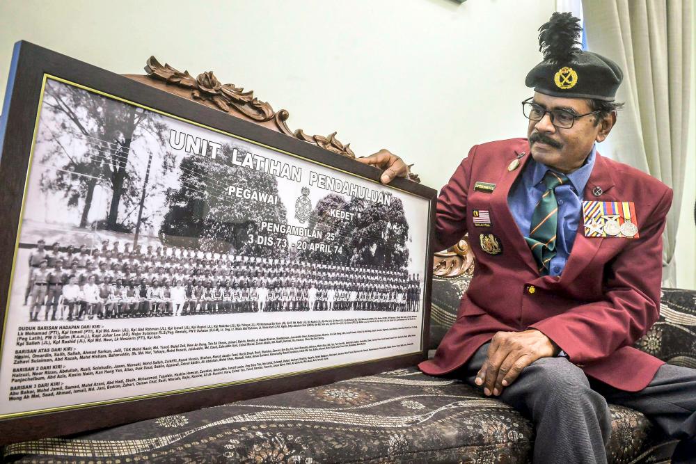 Panir Chellvum showing an old photo of his regiment. – ADIB RAWI YAHYA/THESUN