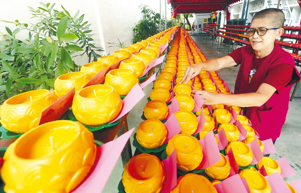 Volunteer Visakha Lim arranging candles at the Mahindarama Buddist Temple in Jalan Kampar, George Town in preparation for Wesak Day on May 15. – MASRY CHE ANI/THESUN