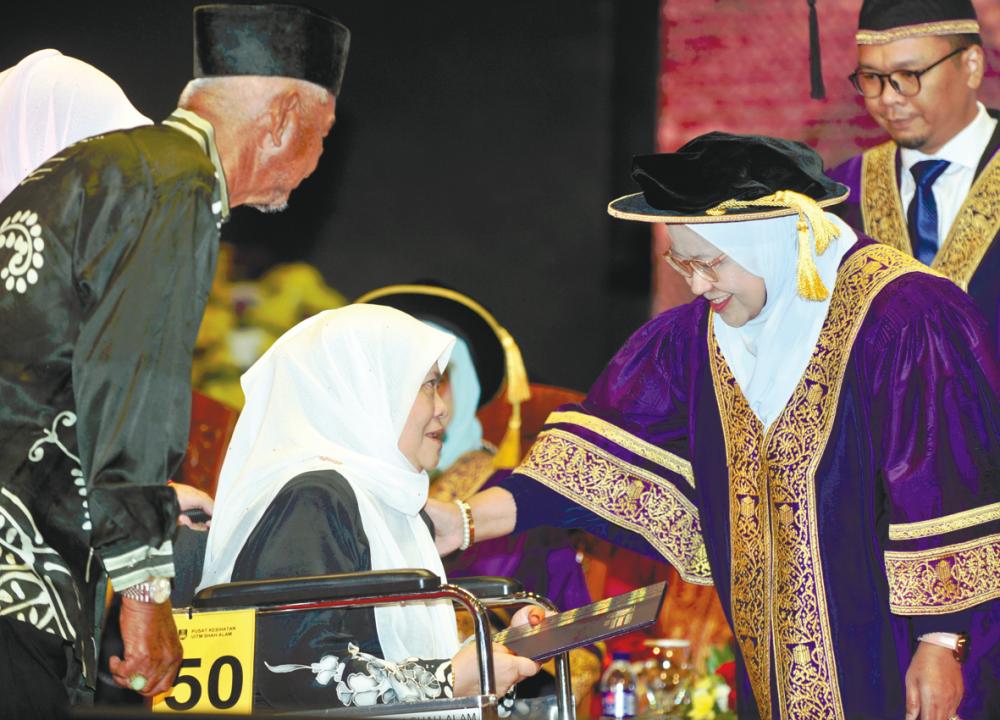 Yahani and Mazmon receiving Muhammad Fakhrur’s degree at the convocation ceremony in Shah Alam.