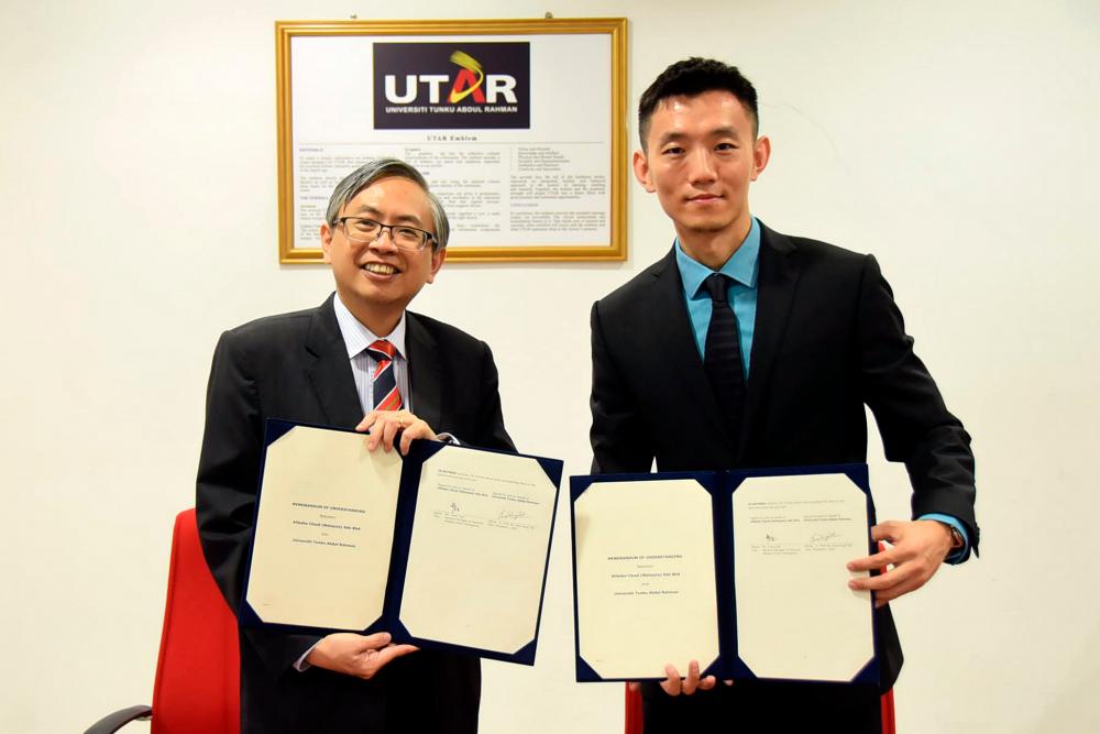 Ewe (far left) and Cao with the signed documents.