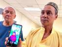 GUA MUSANG, 16 August -- M. Nor Zawawi, 59, (right) shows a photo of his son Nur Asyqin Qistina, 12, who was believed to have died by lightning at his home in Kampung Baru Sungai Raya Luar, Lojing when met by reporters at the Gua Musang General Hospital last night. BERNAMAPIX