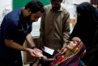 Naveed Ahmed, 30, a doctor, gives medical assistance to flood-affected woman Koonjh, 25, who is suffering from fever, at Sayed Abdullah Shah Institute of Medical Sciences in Sehwan, Pakistan September 29, 2022. - REUTERSPIX