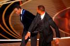 Will Smith (R) hits Chris Rock as Rock spoke on stage during the 94th Academy Awards in Hollywood, Los Angeles, California, U.S., March 27, 2022. REUTERSpix