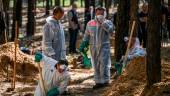 Forensic technicians dig at the site of a mass grave in a forest on the outskirts of Izyum, eastern Ukraine on September 18, 2022. AFPPIX