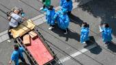 Workers wearing protective gear prepare to unload boxes from a truck (not in picture) on a street during a Covid-19 coronavirus lockdown in the Jing’an district in Shanghai on May 16, 2022. AFPPIX