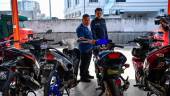 IPOH, 8 August -- Deputy Director of the Perak Road Transport Department (JPJ), Ab Aziz Awang Teh (left) looks at the motorcycles confiscated for various offenses at the OPS Lejang press conference at the Perak State Road Transport Department Office building today. BERNAMAPIX