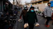 People holding bags of food walk on a street, as the coronavirus disease (Covid-19) pandemic continues in the country, in Beijing, China January 14, 2022. REUTERSpix