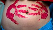 A young woman, with her belly stained in red paint hand marks, takes part in a gathering marking the annual International Safe Abortion Day, on September 28, 2022 in downtown Rome. AFPPIX