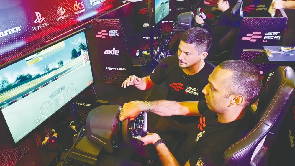 $!Yoong helping a participant try out a racing simulator. – Courtesy of Axle Motorsport