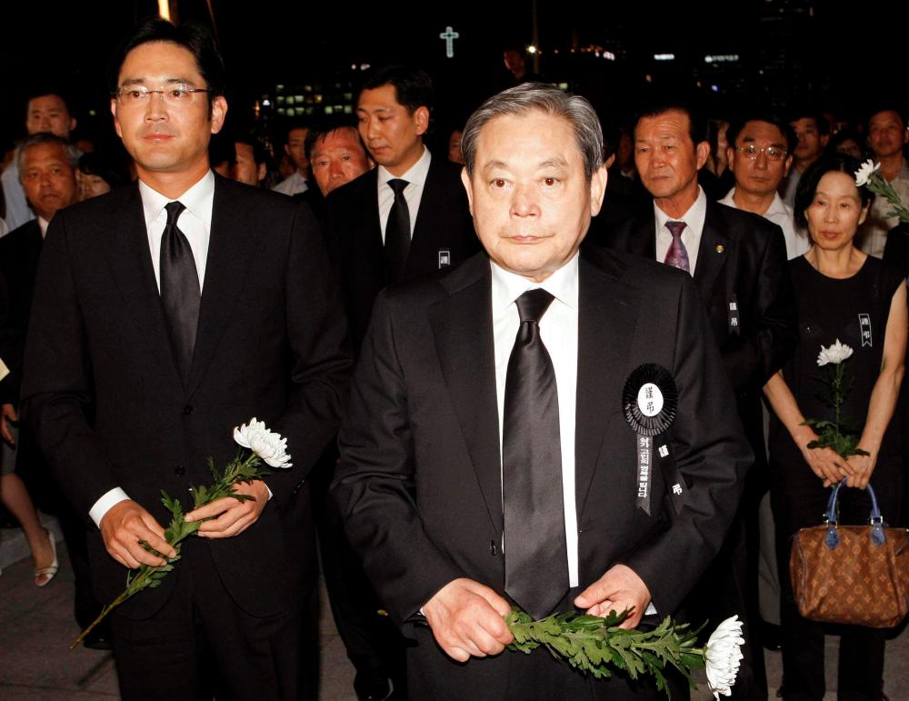 FILE PHOTO: Lee Kun-hee (front), former Samsung Group chairman, and his son Lee Jae-yong (L) wait to make a call of condolence for the late President Kim Dae-jung at a memorial altar at the National Assembly in Seoul August 21, 2009. REUTERS/Korea Pool/File Photo SOUTH KOREA OUT.