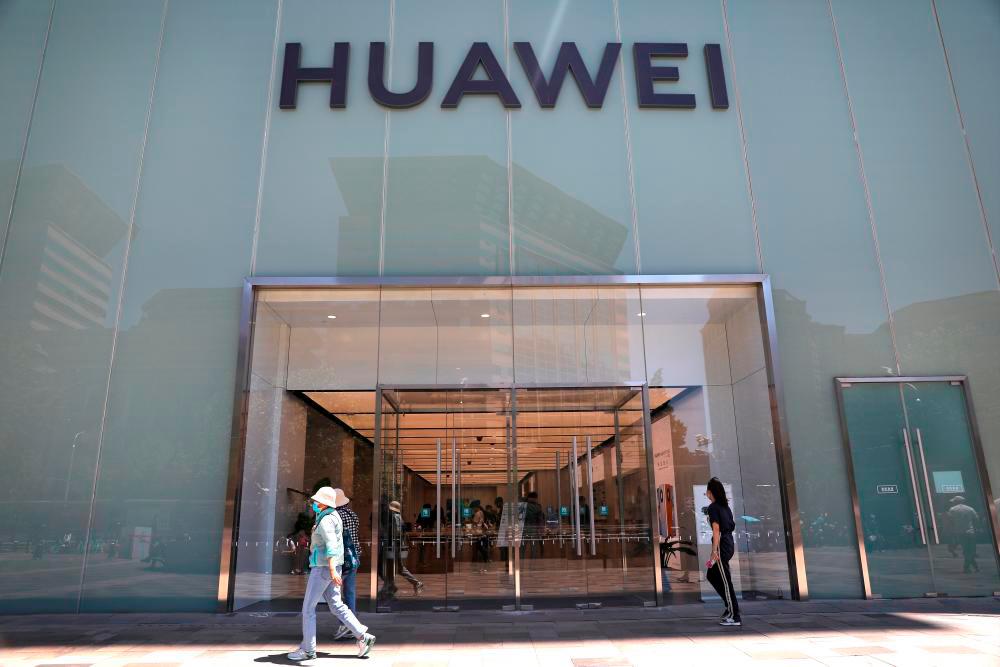 Filepix: People walk past a Huawei store in Beijing, China June 3, 2021. – Reuters