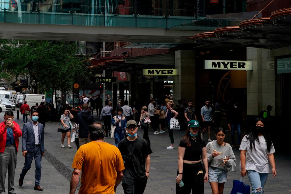 FILE PHOTO: Pedestrians walk through a shopping plaza in the city centre, as the state of New South Wales surpasses the 90 percent double-dose coronavirus disease (COVID-19) vaccination target for its population aged 16 and over, in Sydney, Australia, November 9, 2021. REUTERSpix