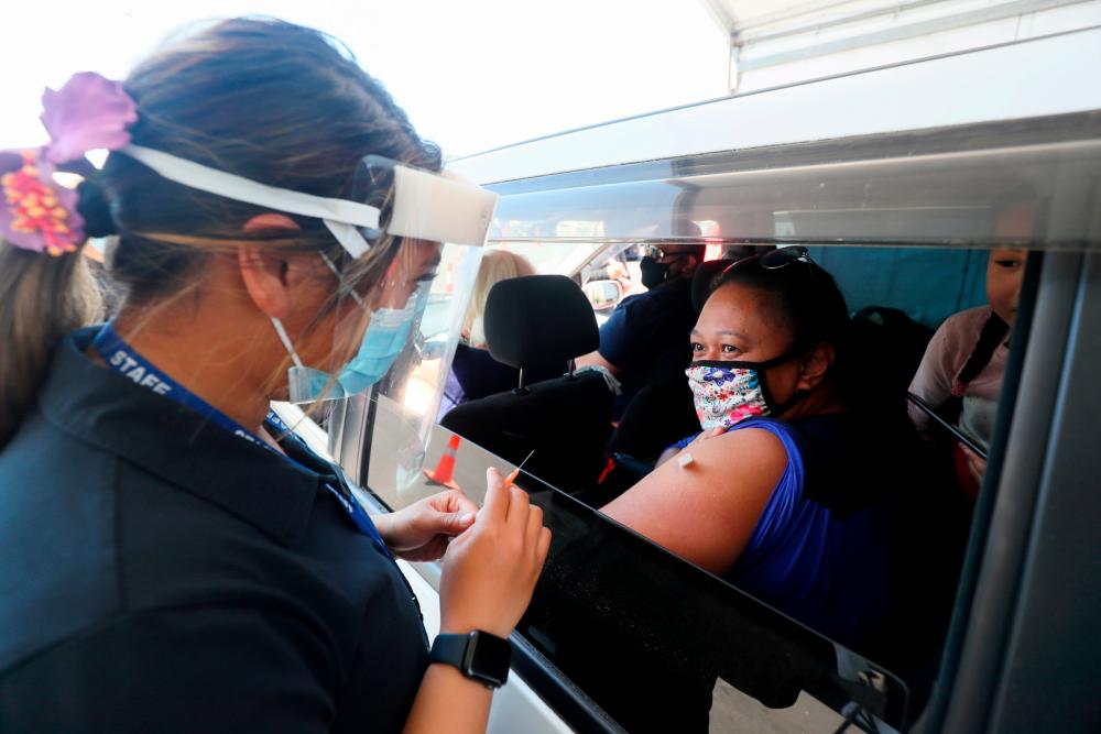 A member of the public receives a Pfizer vaccine at a drive-through coronavirus disease (COVID-19) vaccination clinic in Otara during a single-day vaccination drive, aimed at significantly increasing the percentage of vaccinated people in the country, in Auckland, New Zealand, October 16, 2021. -Reuterspix