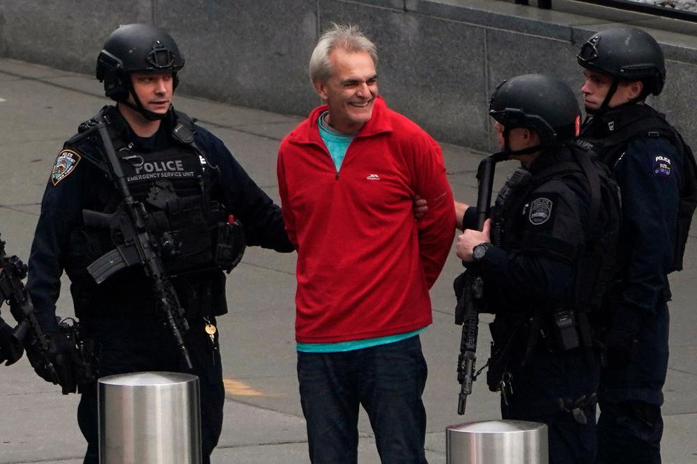 A man is detained by members of the NYPD, after holding a gun under his chin outside the United Nations Headquarters in New York City, U.S., December 2, 2021. REUTERSpix