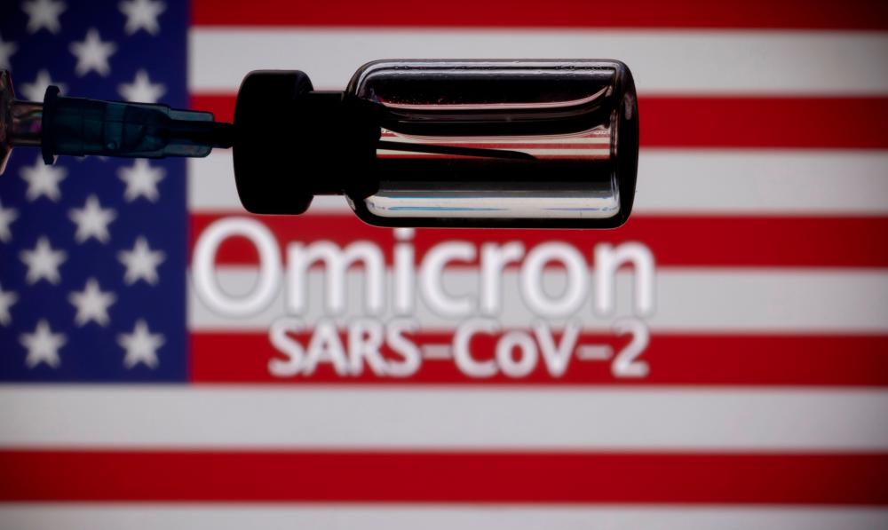 FILE PHOTO: A vial and a syringe are seen in front of a displayed United States' flag and words Omicron SARS-CoV-2 in this illustration taken, November 27, 2021. REUTERSpix