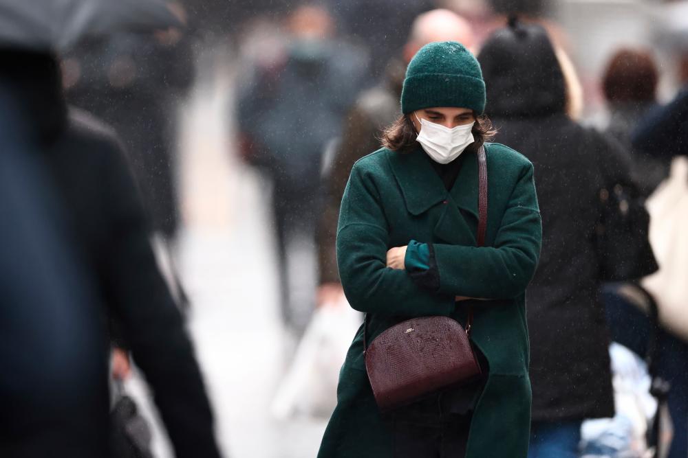 A woman, wearing a protective mask, walks on Montorgueil street in Paris amid the coronavirus disease (COVID-19) outbreak in France, December 3, 2021. REUTERSpix