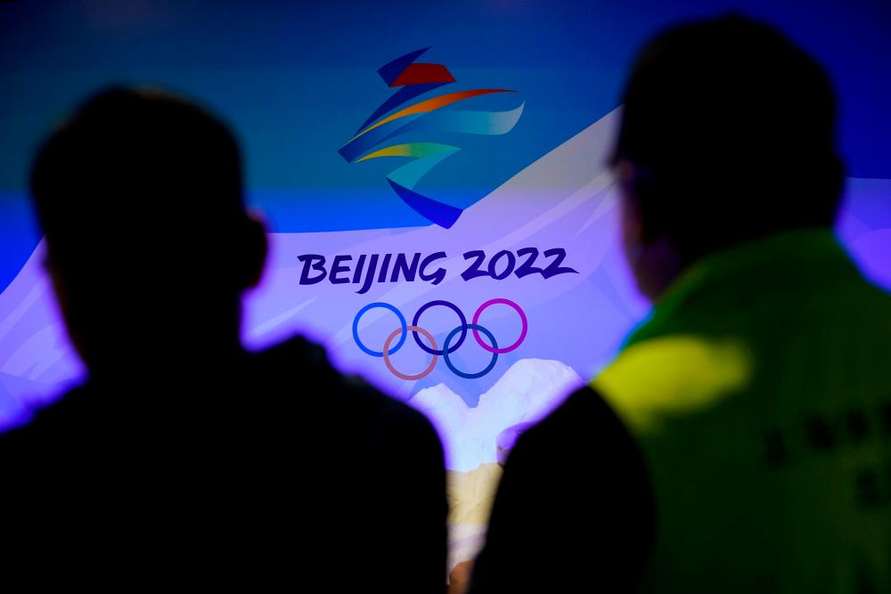 FILE PHOTO: Staff members work near the emblem for Beijing 2022 Winter Olympics displayed at the Shanghai Sports Museum in Shanghai, China, December 8, 2021. REUTERSpix