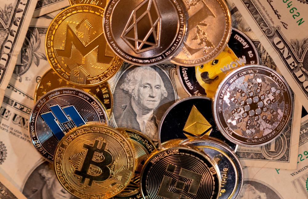 FILE PHOTO: Representations of virtual cryptocurrencies are placed on U.S. Dollar banknotes in this illustration taken November 28, 2021. REUTERSPIX