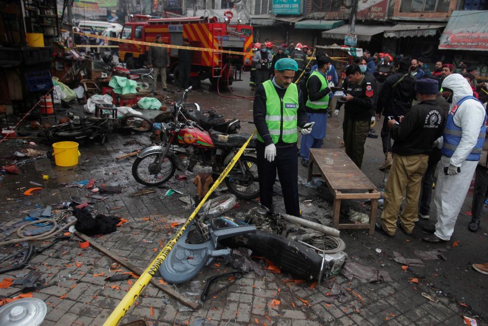 Members of crime scene unit and a bomb disposal team gather after a blast in a market, in Lahore, Pakistan January 20, 2022. REUTERSpix