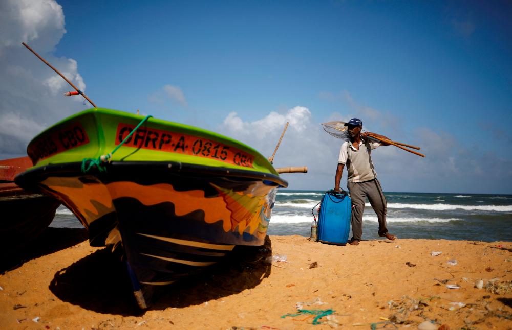 H.S.D. Peiris, 45, carries his empty diesal container as he returns home after fishing, amid the country’s economic crisis, in Colombo, Sri Lanka, May 22, 2022. REUTERSPIX
