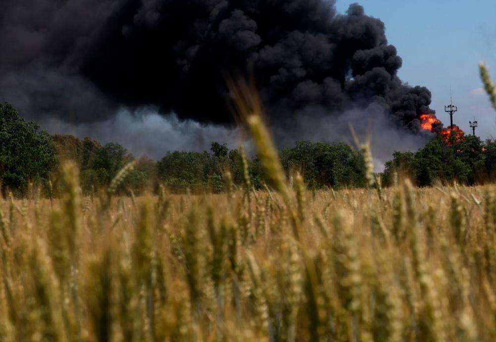 A fire from a gas processing plant continues to burn behind a field of wheat after the plant was hit by shelling a few days prior in Andriivka in the Kharkiv region as Russia’s attack on Ukraine continues in Ukraine, June 21, 2022. REUTERSPIX