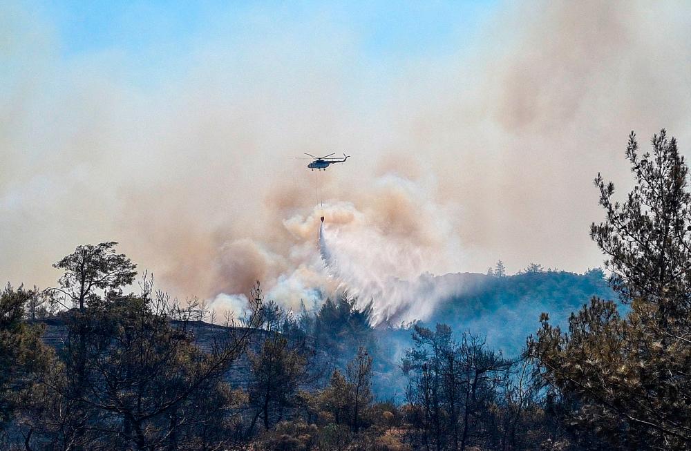 A firefighting helicopter drops water on a wildfire near Marmaris, a town in Mugla province, Turkey, June 22, 2022. REUTERSPIX