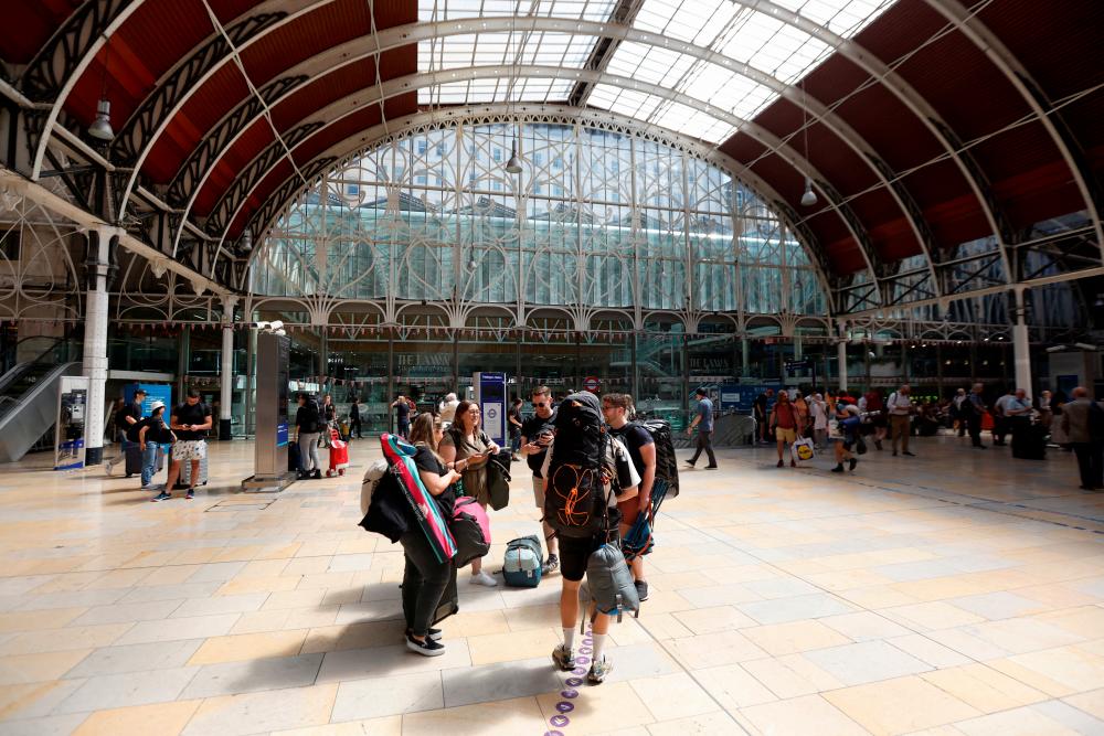 Travellers with camping equipment wait at Paddington Station the day after national rail strike, during six days of travel disruption, in London, Britain, June 22, 2022. REUTERSPIX