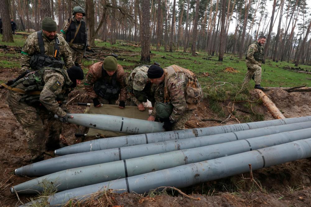 FILE PHOTO: Military sappers place a combat part of a Russian Uragan multiple rocket launch shell left after Russia’s invasion in Kyiv Region, Ukraine April 21, 2022. REUTERSPIX