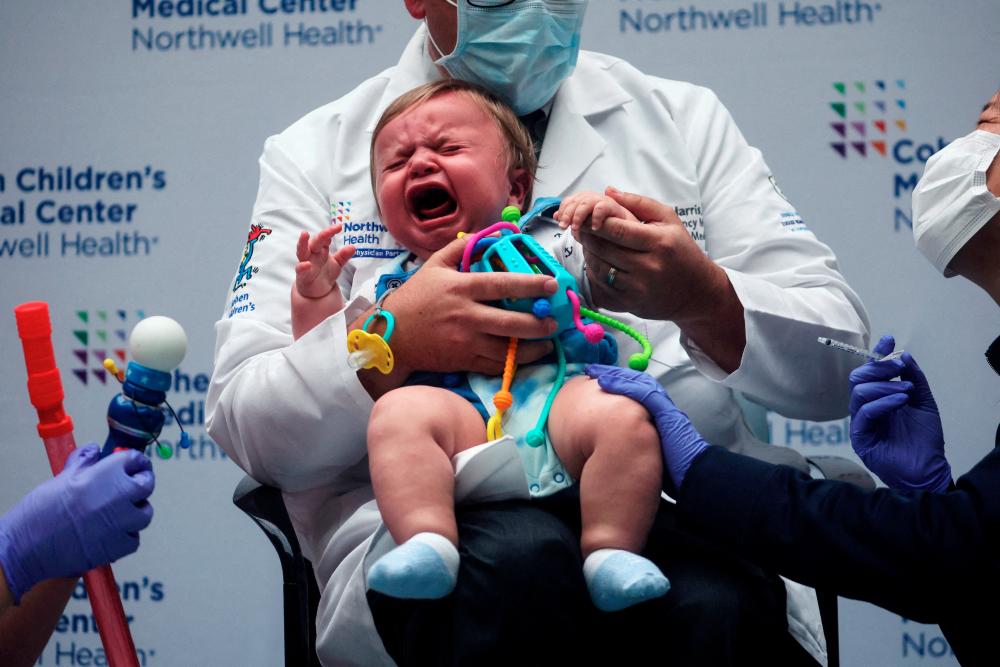 FILE PHOTO: Oliver Harris, 9 months, cries after receiving a vaccine against the coronavirus disease (COVID-19) at Northwell Health's Cohen Children's Medical Center in New Hyde Park, New York, U.S., June 22, 2022. REUTERSPIX