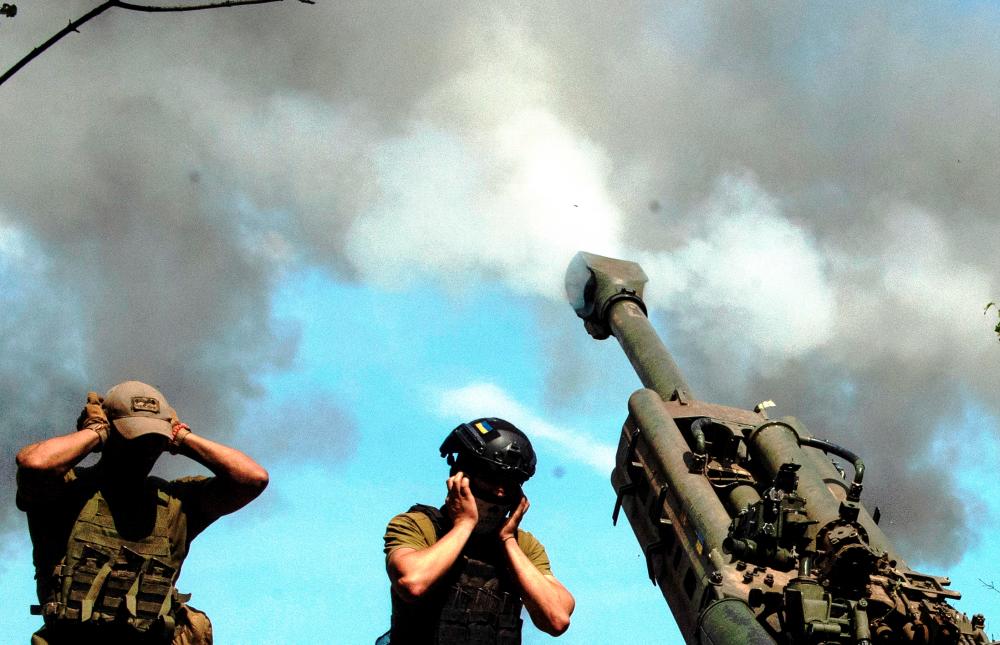 Ukrainian servicemen fire a M777 howitzer at a position on a front line, as Russia's attack on Ukraine continues, in Kharkiv region, Ukraine August 2, 2022. REUTERSPIX