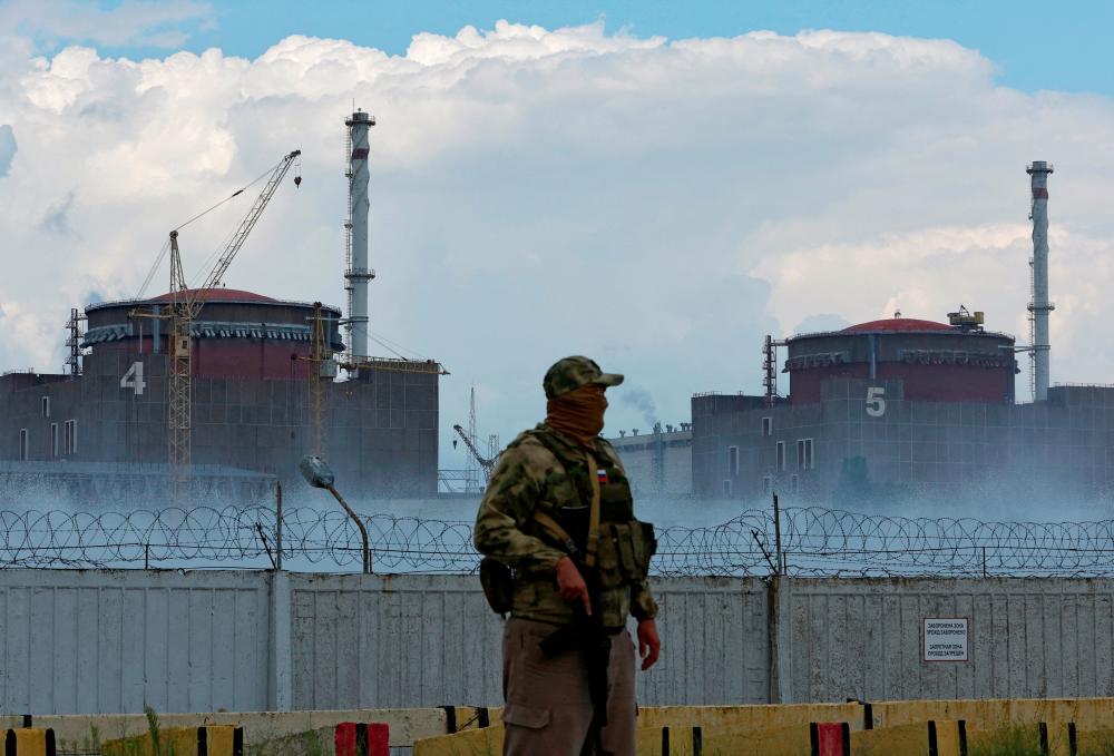 FILE PHOTO: A serviceman with a Russian flag on his uniform stands guard near the Zaporizhzhia Nuclear Power Plant in the course of Ukraine-Russia conflict outside the Russian-controlled city of Enerhodar in the Zaporizhzhia region, Ukraine August 4, 2022. REUTERSPIX