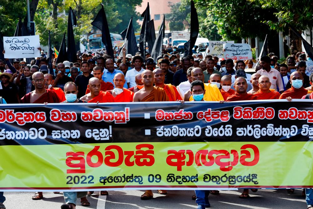 Protesters hold a banner during a march to mark one month since a massive protest forced then Sri Lankan President Gotabaya Rajapaksa to flee the country and step down, amid the country’s economic crisis, in Colombo, Sri Lanka, August 9, 2022. REUTERSPIX