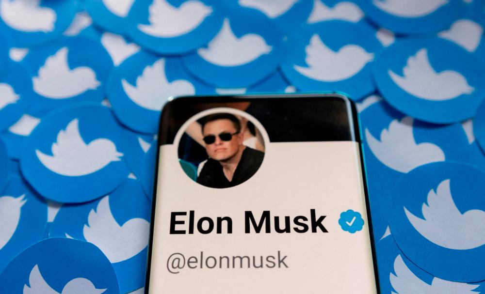 FILE PHOTO: FILE PHOTO: Elon Musk's Twitter profile is seen on a smartphone placed on printed Twitter logos in this picture illustration taken April 28, 2022. - REUTERSPIX