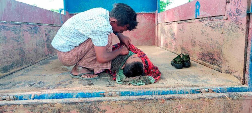 SENSITIVE MATERIAL. THIS IMAGE MAY OFFEND OR DISTURB A man watches the corpse of a child at a local school that was damaged by an air attack carried out by the Myanmar military against the People Defense Force, in Sagaing, Myanmar September 16, 2022 - REUTERSPIX
