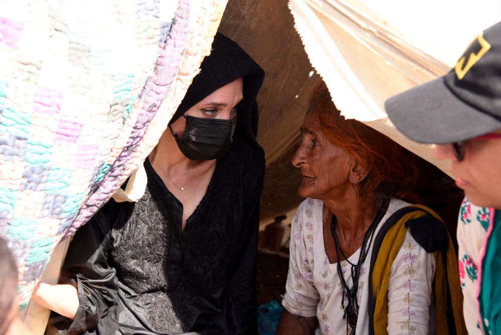 Angelina Jolie listens to a displaced woman following rains and floods during the monsoon season, in village Ibrahim Chandio, Dadu, Pakistan/AFPPix
