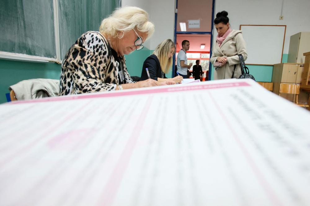 A woman waits to vote during presidential and parliamentary elections at a polling centre in a school in Sarajevo, Bosnia and Herzegovina October 2, 2022. - REUTERSPIX