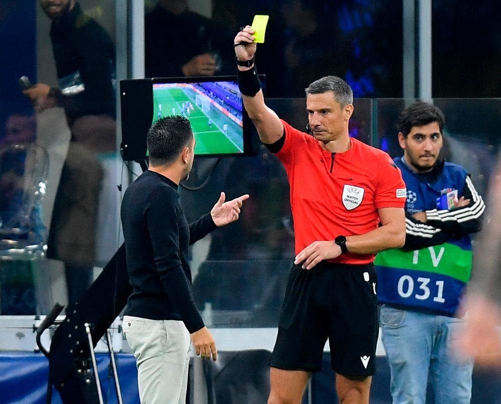 Soccer Football - Champions League - Group C - Inter Milan v FC Barcelona - San Siro, Milan, Italy - October 4, 2022 FC Barcelona coach Xavi is shown a yellow card by referee Slavko Vincic after their first goal was disallowed REUTERSPIX