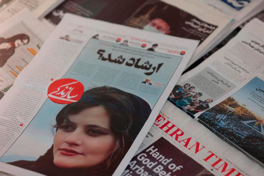 FILE PHOTO: A newspaper with a cover picture of Mahsa Amini, a woman who died after being arrested by the Islamic republic’s “morality police” is seen in Tehran, Iran September 18, 2022/REUTERSPix