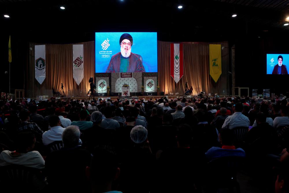 Lebanon's Hezbollah leader Sayyed Hassan Nasrallah addresses his supporters through a screen during the opening of a local exhibition, in Beirut's southern suburbs, Lebanon October 27, 2022. - REUTERSPIX
