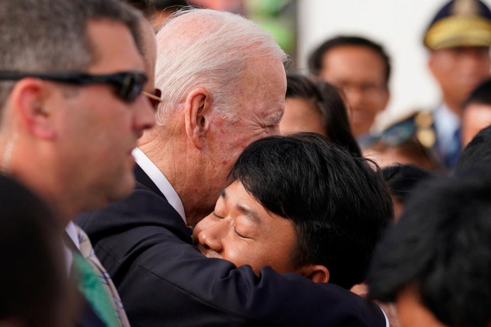 U.S. President Joe Biden receives a hug while greeting embassy staff and families at the Phnom Penh International Airport as he arrives to attend the 2022 ASEAN summit in Phnom Penh, Cambodia, November 12, 2022. REUTERSPIX