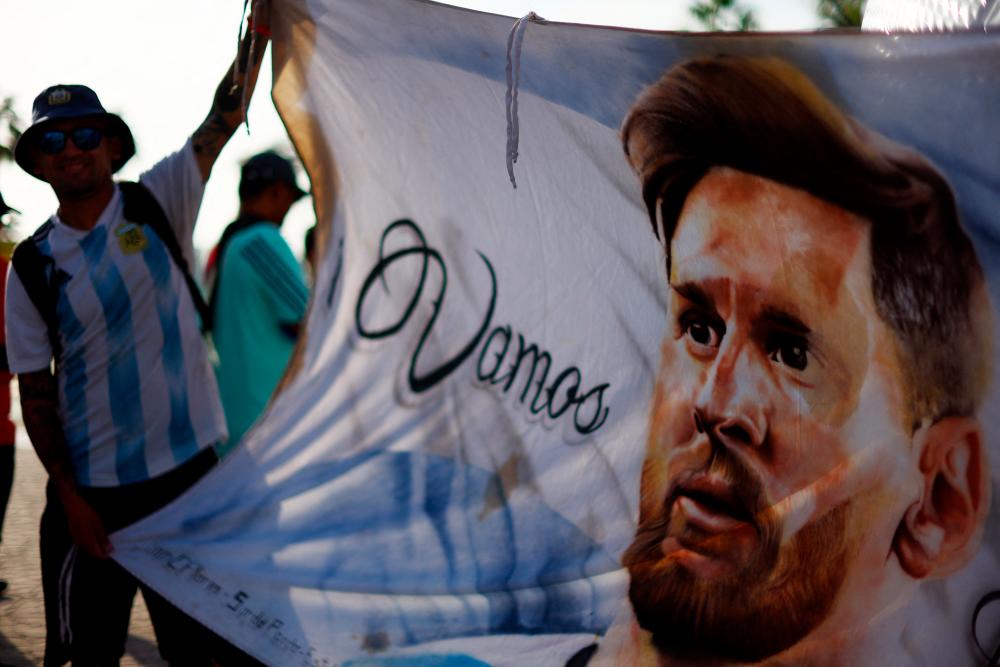 $!A Argentina fan holds a Lionel Messi flag. – REUTERSPIX