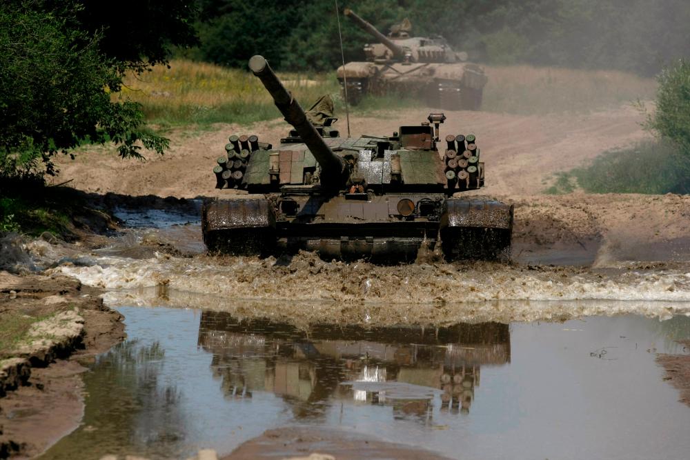 The Polish tank PT-91, a newer model of the Soviet tank T-72, drives through water at the military base in Bedrusko near Poznan, western Poland, July 9, 2013. REUTERSPIX