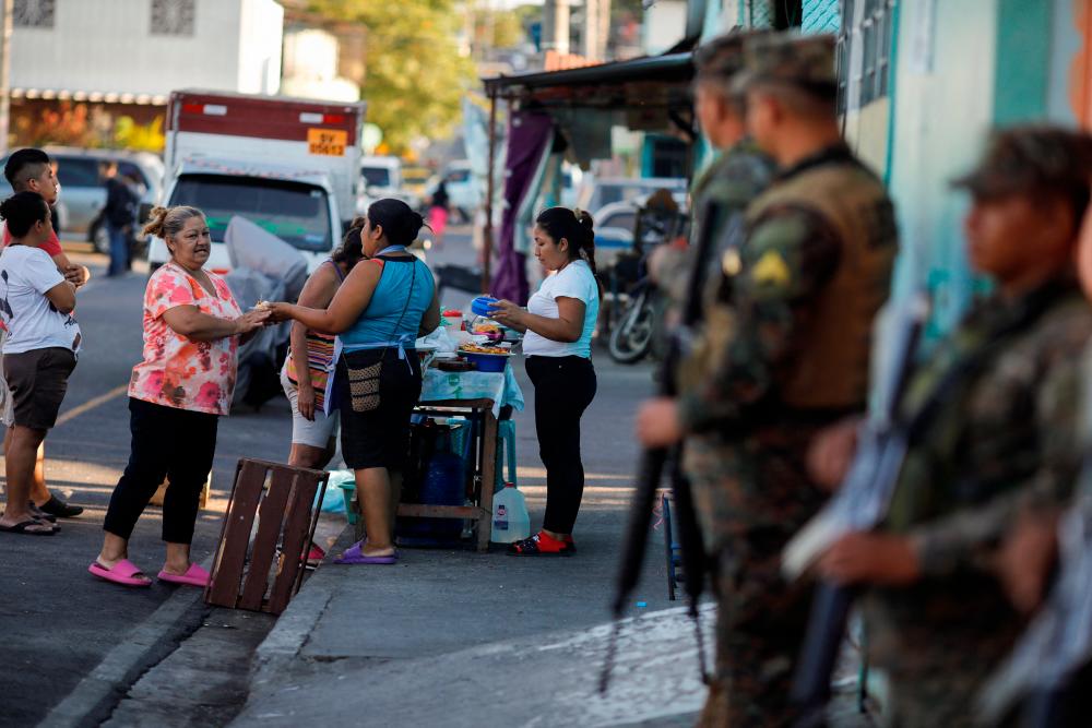 Women sell snacks on a street of Las Margaritas neighborhood during an anti-gang patrol following a year-long state of emergency against gangs, in Soyapango, El Salvador March 24, 2023. REUTERSpix