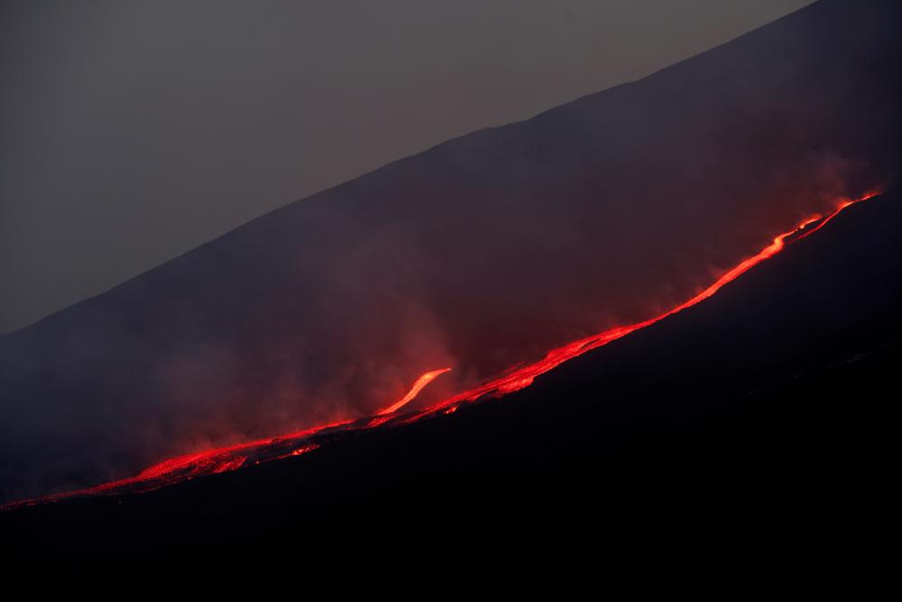 FILE PHOTO: Lava flows downhill as Mount Etna erupts, as seen from Pizzi Deneri on the north side of volcano, on the island of Sicily, in Catania, Italy, May 31, 2022. Picture taken May 31, 2022. - REUTERSPIX