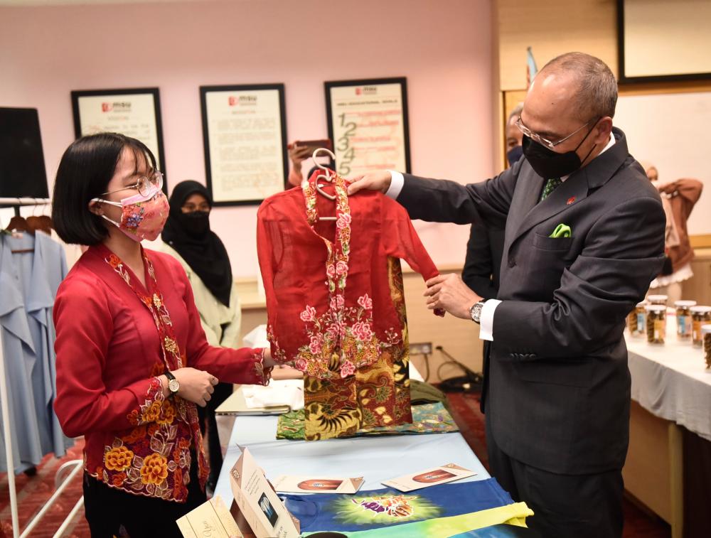 $!A MSU entrepreneur showcasing her product to Prof Tan Sri Dr Mohd Shukri