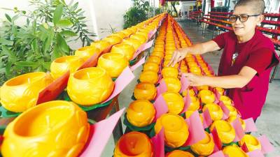 Volunteer Visakha Lim arranging candles at the Mahindarama Buddist Temple in Jalan Kampar, George Town in preparation for Wesak Day on May 15. – MASRY CHE ANI/THESUN