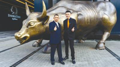 Kim Hong (left) and I-Bhd executive director Lim Boon Soon with the Charging Bull, a landmark at the Finance Avenue in i-City precinct. The Charging Bull at Finance Avenue in i-City symbolises resilience of the Malaysian economy and the emergence of i-City as a financial hub of the future in Selangor.