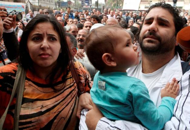 FILE PHOTO: Alaa Abdel Fattah (R), one of the activists who was summoned by the public prosecutor on whether he had a role in the recent violent anti-Islamists protests, arrives with his wife and child to the public prosecutor’s office in Cairo, Egypt/REUTERSPix
