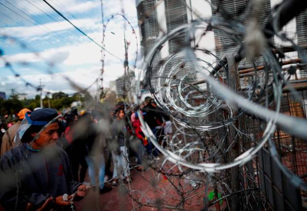 A demonstrator looks at a barricade covered in barbed wire as protests continue amid a stalemate between the government of President Guillermo Lasso and largely indigenous demonstrators who demand an end to emergency measures, in Quito, Ecuador/REUTERSPix